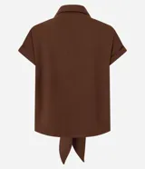 Blusa color marrón con cuello solapa, mangas cortas con vuelta y cierre frontal de botones. Cuenta con un diseño texturizado y un lazo para anudar en el bajo.