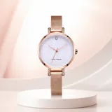 Reloj analógico de mujer con caja redonda de metal en tono oro rosa, esfera blanca con acabado brillante y malla metálica ajustable. Diseño minimalista y elegante.
