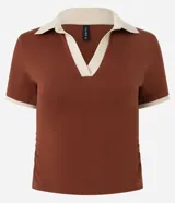 Blusa polo color marrón con cuello y mangas con borde en color crema.