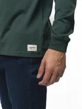 Remera de manga larga con cuello redondo, confeccionada en algodón, de corte clásico y diseño minimalista con detalle de etiqueta pequeña en el ruedo.