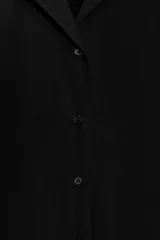 Vestido corto de algodón con cuello solapa, manga corta y cierre frontal con botones. Presenta un diseño evasé con bolsillos laterales ocultos en las costuras.