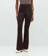 Pantalón de corte flare confeccionado en punto roma, con cintura estructurada, detalle de hebilla decorativa, cierre frontal y bolsillos posteriores.