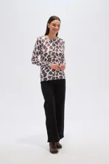 Sweater de punto con estampado floral en tonos rosados y marrones sobre base color crema, de cuello redondo y manga larga.