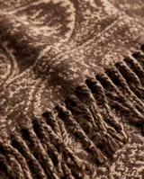 Poncho marrón con diseño estampado y detalles de flecos en el ruedo inferior.
