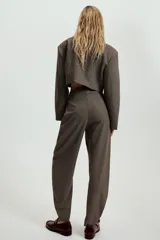 Pantalón de tiro medio con estampado de cuadros pequeños, bolsillos laterales y cierre frontal con cremallera y gancho metálico.