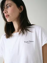 Camisón blanco de algodón, de corte holgado, manga corta y largo por encima de las rodillas. Presenta una pequeña estampa localizada en el pecho y aberturas en los laterales.