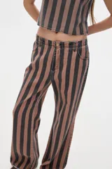 Pantalón de jean corte flare, tiro medio, con rayas verticales color marrón y negro.