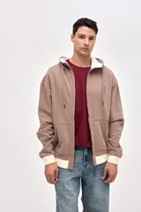 Canguro con cierre frontal metálico, confeccionado en felpa con friza. Presenta capucha con interior en contraste, cuello alto, bolsillos laterales y detalles de bordado de la marca en el pecho y las mangas. Posee un calce relajado con puños y ruedo en contraste.