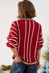 Cardigan de punto a rayas verticales en tonos marrón chocolate, blanco y amarillo, con escote en V, mangas largas y cierre frontal con botones.