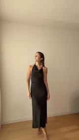 Vestido largo negro de punto con hilo brillante, diseño ajustado, escote halter y cuello drapeado.