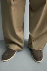 Mocasín destalonado de hombre, fabricado en piel con acabado serraje (gamuza), de horma redonda y suela a contraste con ligero tacón.