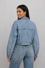 Campera cropped de jean en color gris lavado, con diseño de corte holgado, mangas amplias, cuello clásico y cierre frontal con botones metálicos. Incluye dos bolsillos frontales con solapa.
