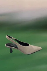 Zapato destalonado de cuero vacuno color beige, con punta fina y taco bajo tipo kitten heel.