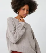 Suéter largo de punto texturizado color gris topo, con cuello redondo y mangas largas.