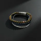 Pulsera triple para hombre compuesta por una hilera de cuentas de piedra natural en tonos verdes y rojizos, una hilera de cuero trenzado azul oscuro y una hilera de cadena de eslabones de acero. Cuenta con un cierre magnético metálico.