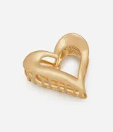 Pinza para el pelo con diseño de corazón calado, confeccionada en aleación de zinc con acabado en oro envejecido y cierre de resorte.