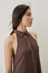 Vestido midi color marrón chocolate, con cuello camisero y abotonadura frontal oculta, escote halter y diseño sin mangas con silueta evasé.