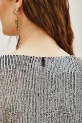 Remera azul marino con lentejuelas verticales, cuello redondo y mangas cortas.