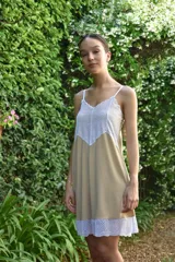 Camisón de algodón color beige con escote en V y ruedo decorados con amplia puntilla blanca. Presenta breteles finos y espalda recta.