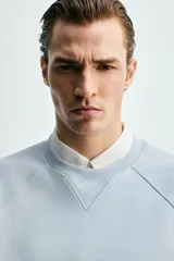 Sudadera de corte regular fit confeccionada en tejido de mezcla de algodón con estructura de piqué y efecto lavado. Presenta cuello redondo, manga larga y acabados en rib en puños y ruedo.