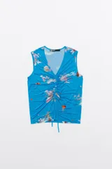 Top sin mangas con estampado de olas en tonos azules, corte recto, escote en V pronunciado y cordones ajustables.