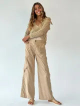 Pantalón cargo violeta de corte ancho, con bolsillos laterales y cintura con cinturón trenzado blanco.