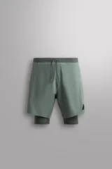Short de entrenamiento verde con calza interior ajustada. Cuenta con cintura elástica ajustable con cordón, bolsillos laterales con cierre de cremallera, bajo con aberturas laterales y detalle de logo estampado.