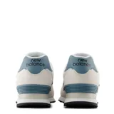 Championes urbanos New Balance modelo 574, color gris claro y blanco con detalles en azul. Confeccionados en gamuza y malla, cuentan con el logo N característico en los laterales y entresuela con tecnología ENCAP.