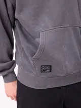 Canguro con capucha de calce holgado, color azul con efecto lavado. Presenta bolsillo frontal tipo canguro, logo de la marca estampado en el pecho y etiqueta pequeña en el ruedo.