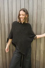 Poncho tejido en hilo de algodón con lurex color negro y dorado, con flecos en el ruedo.