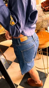 Bermuda de jean color negro, con corte recto y largo hasta la rodilla.