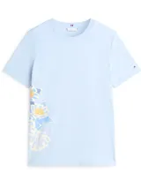 Remera de corte regular confeccionada en algodón, color celeste, con cuello redondo y mangas cortas. Presenta un diseño estampado de flores en el lateral inferior izquierdo y el logo de la marca bordado en la manga.