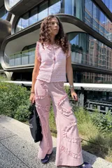 Pantalón de pierna ancha color rosado, con diseño holgado y detalle de volados en forma orgánica y ondulada a lo largo de las piernas.