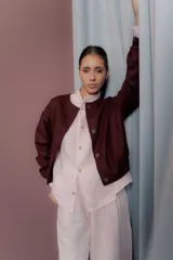 Bomber de corte corto y silueta relajada, confeccionada en paño de lana con cashmere. Presenta cuello redondo, cierre frontal con botones y mangas largas.