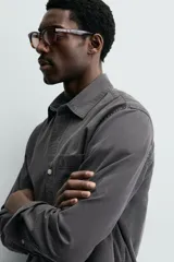 Camisa de corte relajado confeccionada en una mezcla de lyocell y algodón con efecto lavado. Presenta cuello solapa, manga larga con puños abotonados, bolsillo de plastrón en el pecho y cierre frontal con botones.