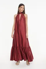 Vestido largo de viscosa color bordó, con cuello halter alto, corte holgado y volante fruncido en el bajo.