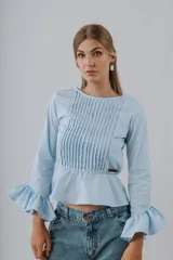 Camisa de manga larga color negro con detalles de alforzas en el pecho, corte peplum y puños acampanados con volados.