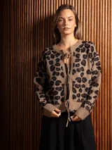Saco de punto con estampado animal print, de corte recto y manga larga. Presenta cierre frontal mediante lazos ajustables y terminaciones en tejido acanalado.