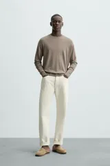 Jersey color crudo de tejido de punto, con cuello redondo y mangas largas. Corte amplio y terminaciones en rib.