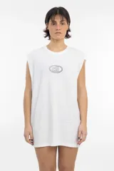 Musculosa blanca de corte holgado, con cuello redondo y sisas amplias. Presenta un pequeño logo bordado en el pecho, enmarcado en un óvalo.