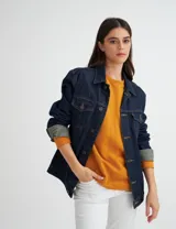 Campera de jean unisex con calce clásico, cuello camisero, cierre frontal con botones metálicos y bolsillos frontales con solapa.