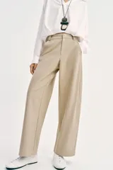 Pantalón barrel color azul marino, de tiro bajo, pernera holgada con diseño redondeado que se estrecha hacia el tobillo, con bolsillos delanteros y cierre frontal.