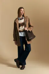 Pilot de largo medio color azul marino, con capucha integrada, cierre frontal oculto y bolsillos aplicados con tapa. Presenta una silueta recta y diseño funcional.