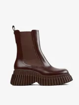 Botín Chelsea de cuero color marrón chocolate, con elásticos laterales y tirador trasero. Plataforma con suela de goma con diseño acanalado.
