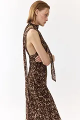 Vestido largo de gasa con estampado animal print en tonos marrones y beige, cuello halter con pañuelo incorporado, escote en V y diseño ajustado.