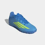 Championes de fútbol Adidas F50 Club para pasto sintético, color azul con detalles en amarillo neón. Presentan exterior Fiberskin con textura 3D, lengüeta flotante ventilada y suela de caucho con tapones pequeños para mayor tracción.