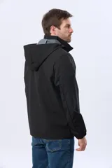 Campera repelente al agua y cortaviento de color negro, con capucha desmontable, cierre frontal y parche circular en el pecho.