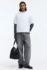 Remera blanca boxy de punto liviano de algodón, con hombros caídos, cuello redondo acanalado y corte oversized.