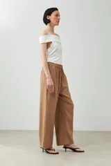 Pantalón negro de lino, corte palazzo, con cintura elástica y cordón ajustable.