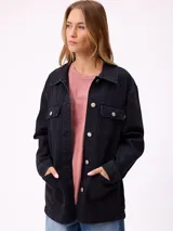 Campera de denim color negro, estilo camisaco, con cierre frontal de botones metálicos, bolsillos con solapa en el pecho y bolsillos laterales. Confeccionada en algodón.